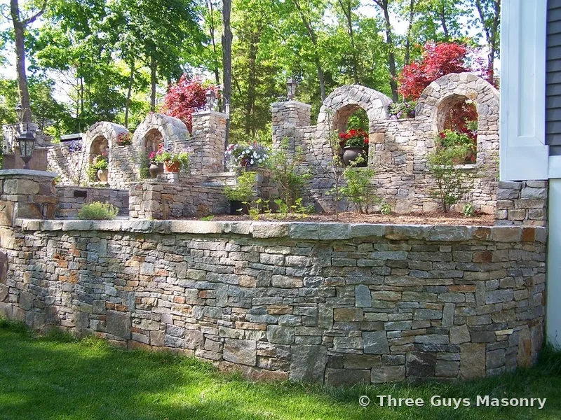 Natural stone retaining wall built by Three Guys Masonry